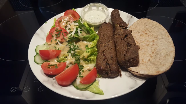 seekh kebab with salad, raita and pita bread