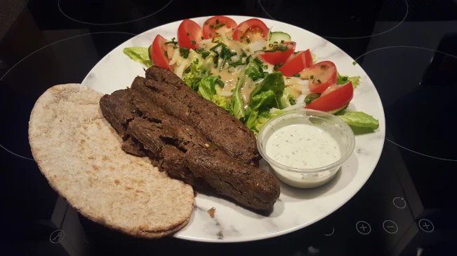 seekh kebab with salad raita and pita bread