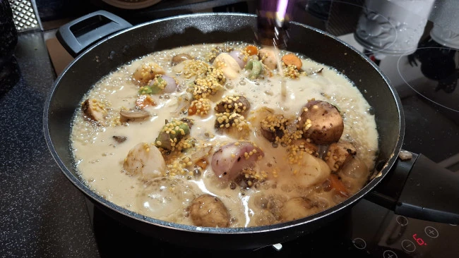 adding beer to stew in pan