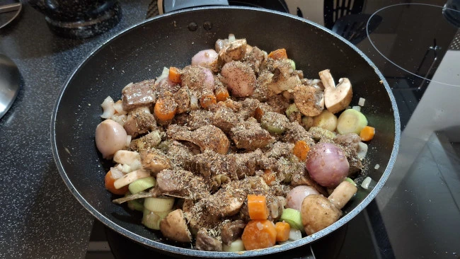 seasoning added to beef and veg in pan