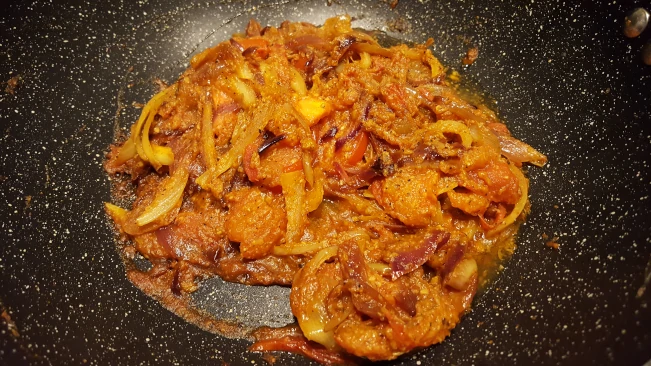 onions with curry paste and tomatoes in a pan onions paste tomatoes