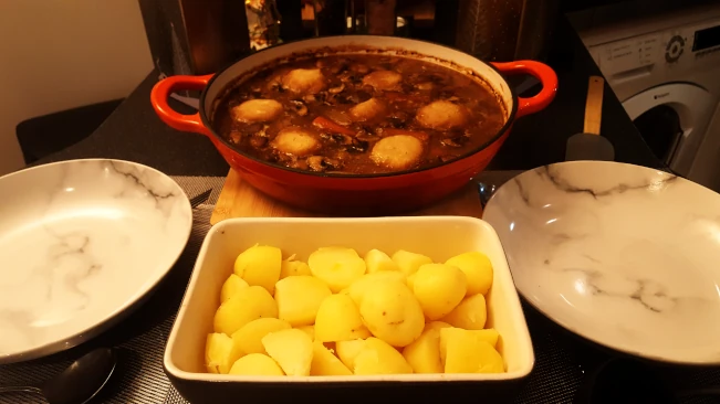 beef stew and dumplings layed out to serve beef stew and dumplings and dishes