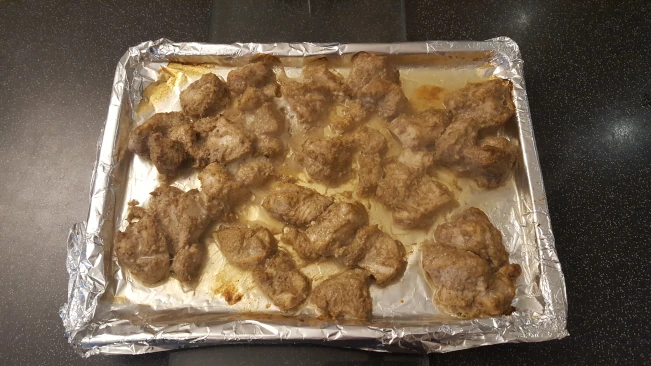 cooked chicken chunks on a tray for butter chicken cooked chicken chunks on tray