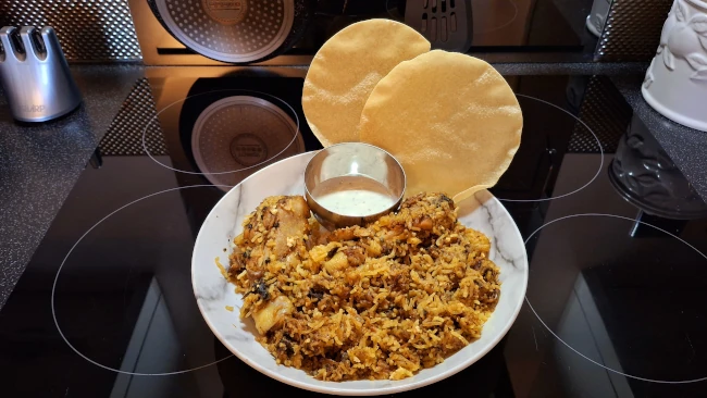 chicken biryani served with raita and popadoms chicken biryani raita popadams
