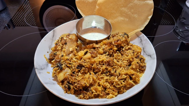 chicken biryani served with raita and popadoms chicken biryani raita popadams