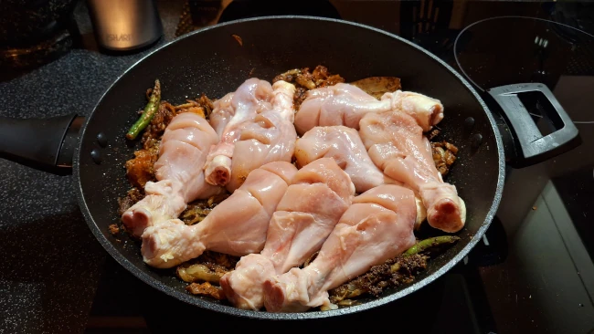 chicken drumsticks added to wok for chicken biryani chicken drumsticks added to wok