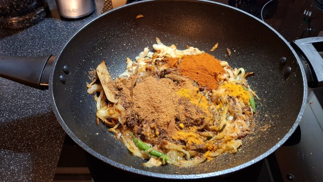 masala and spices added to wok for chicken biryani masala and spices added to wok