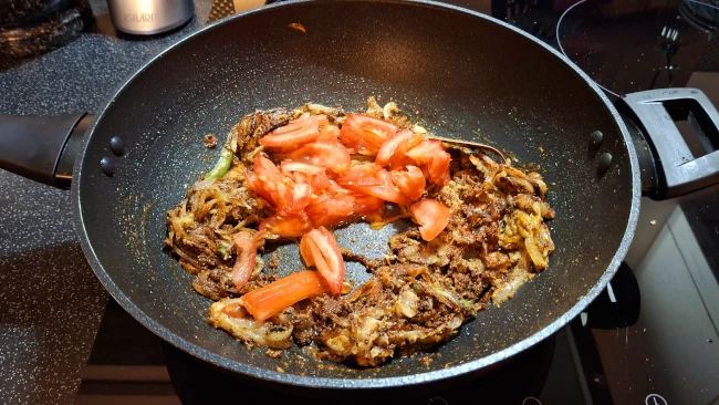 tomatoes added to wok for chicken biryani tomatoes added to wok