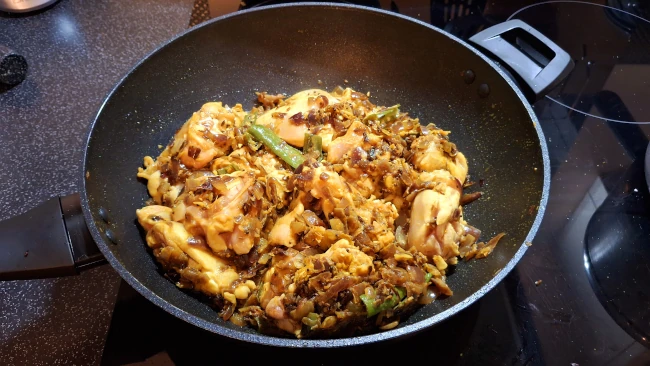 chicken coated in spices in a pan for curry leaf masala chicken fry chicken coated in spices in a pan