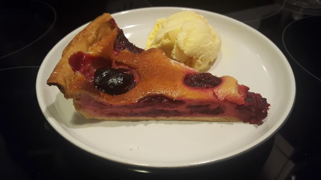 a slice of damson and soured ceam tart with icecream on a plate damson and soured cream tart and icecream plates