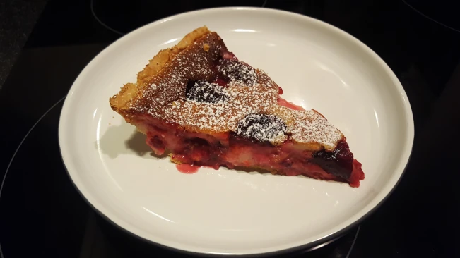 a slice of damson and soured ceam tart on a plate damson and soured cream tart
