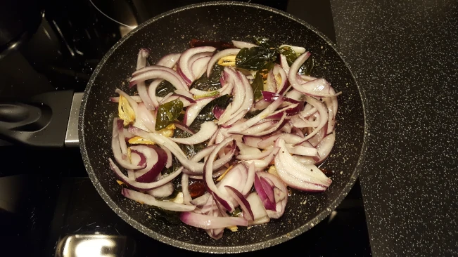 spices and onions frying for dhal with fried spices spices and onions frying