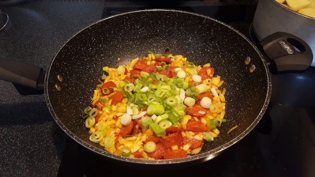 spring onions added to onions and chorizo