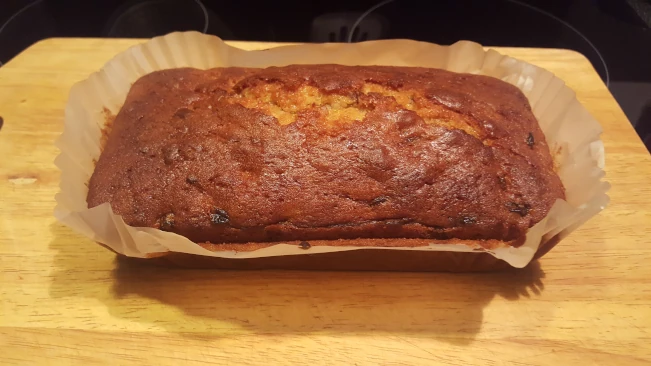fruit cake in baking paper on a chopping board fruit cake in baking paper