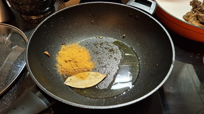 curry powder and bay leaf in pan for jamaican beef & butter bean curry curry powder and bay leaf in pan