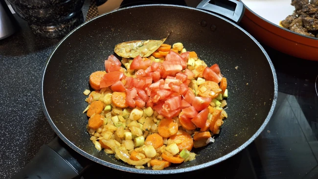 tomato added to pan for jamaican beef & butter bean curry tomato added to pan