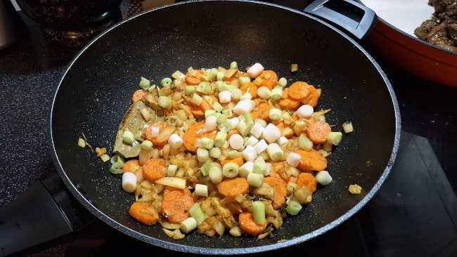 white spring onions added to pan for jamaican beef & butter bean curry white spring onions added to pan