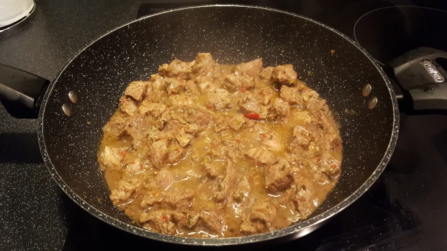 jerked pork curry cooking in pan
