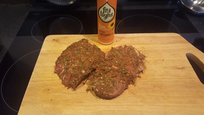 raw jerked pork steaks on a board