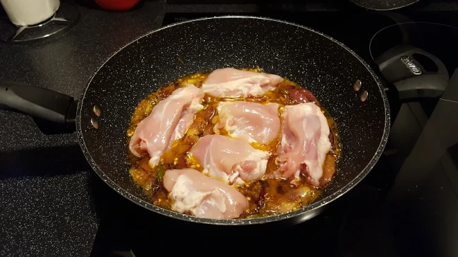 chicken added to the onions in a wok chicken added