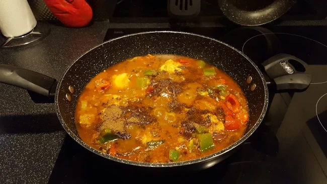garam masala sprinkled onto karahi chicken curry garam masala added