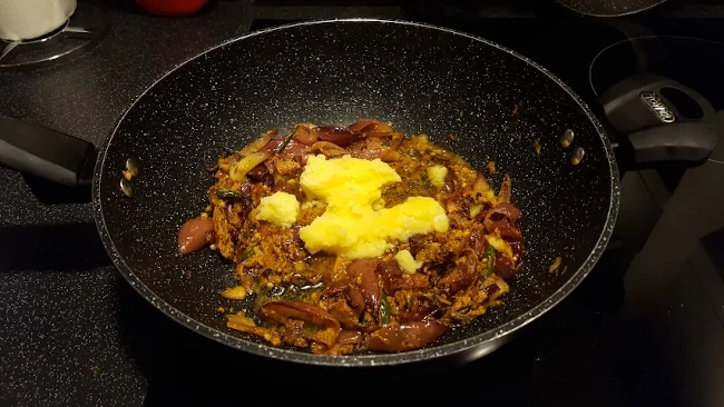 ghee added to the onions in a wok ghee added to onions