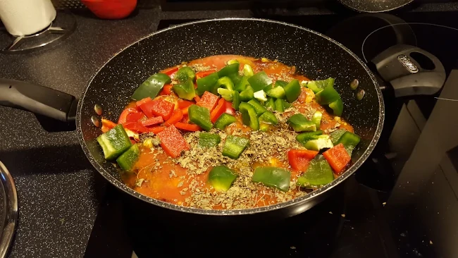 peppers and dried fenugreek leaves added to the wok peppers added with methi leaves