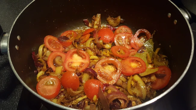 tomatoes added to onions for lamb kofta curry tomatoes added to onions