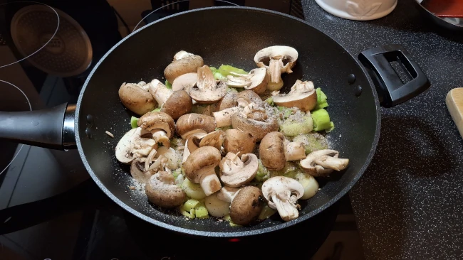 mushrooms added to leeks in a pan for luxury chicken pie with mushrooms & leeks mushrooms added to leeks