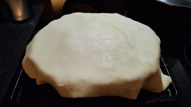putting the lid on the luxury chicken pie with mushrooms & leeks raw pastry draped over pie base