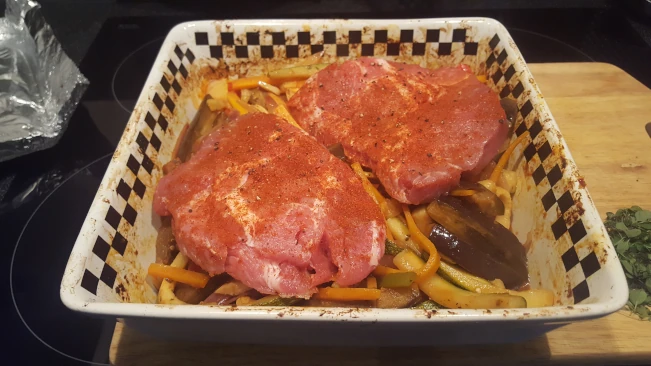 raw seasoned pork steaks added to dish for Mediterranean style vegetables with pork steaks raw seasoned pork steaks added to dish