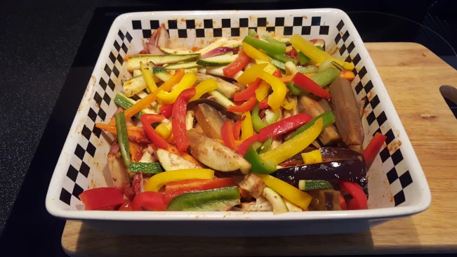 sliced peppers added to dish for Mediterranean style vegetables with pork steaks veg part cooked in oven dish 01
