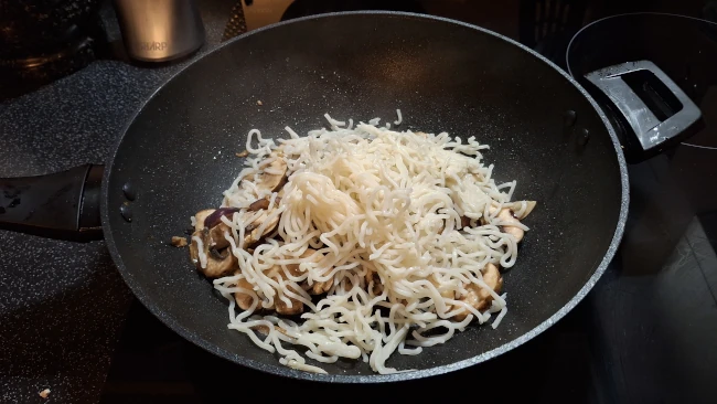noodles added to wok for mushroom chow mein noodles added to wok