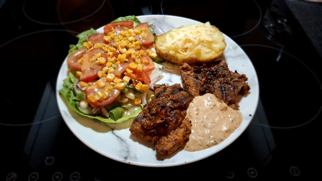 peri peri pork steaks served with side salad & jacket potato with cheese peri peri pork steak dinner