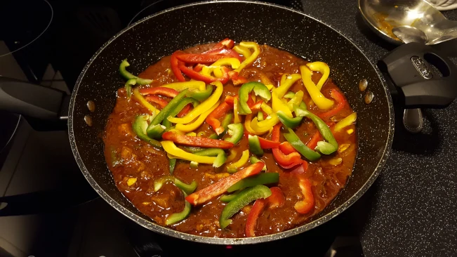 diced pork for pork madras peppers added to pan