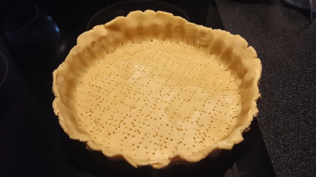 raw pastry flan base pricked for the Ultimate Quiche lorraine raw pastry flan base pricked