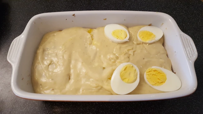 sliced egg added to dish for smoked haddock bacon bake sliced egg added