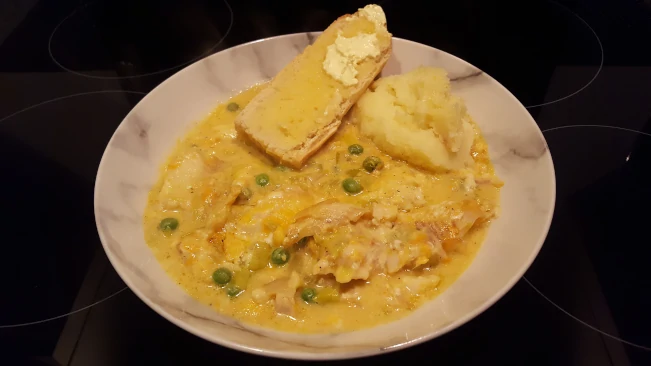 smoked haddock in cheese sauce served with mashed potatoes and warm buttered baguette smoked haddock in cheese sauce plated