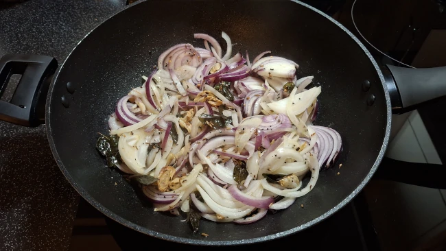 onions frying in a wok for spicy balti potatoes onions frying in a wok