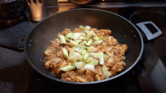 onions added to fried chicken in wok