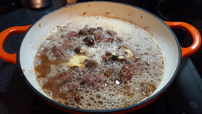 ale added to steak in a pan