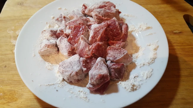 floured steak on a plate