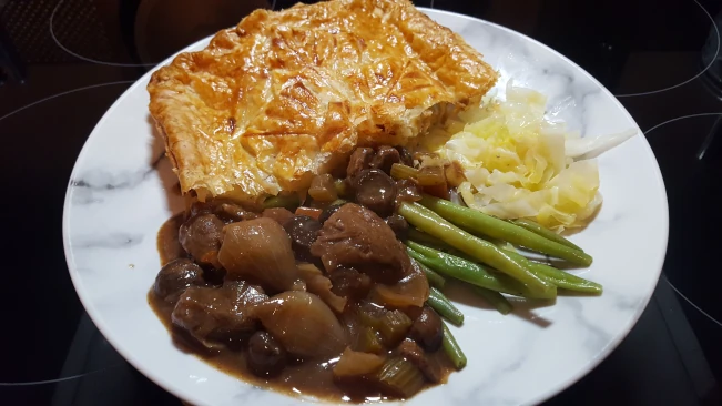 steak and ale pie with veg on a plate