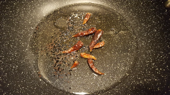 chillies and seeds for tarka dhal seeds and chilli cooking in oil