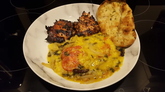 spicy chicken masala served with tarka dhal and naan as sides spicy chicken masala tarka dhal and naan